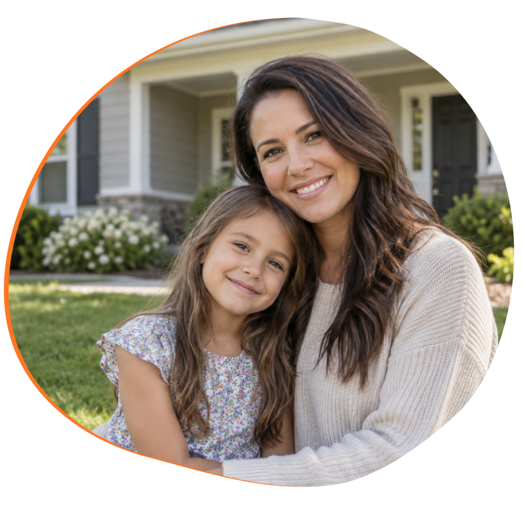 Woman with young daughter sitting together in front of a single-family home